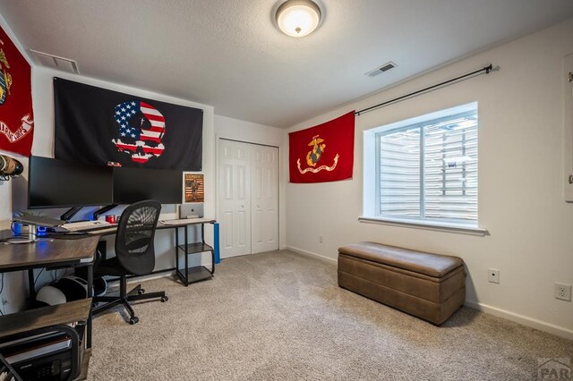 carpeted office space with baseboards and visible vents