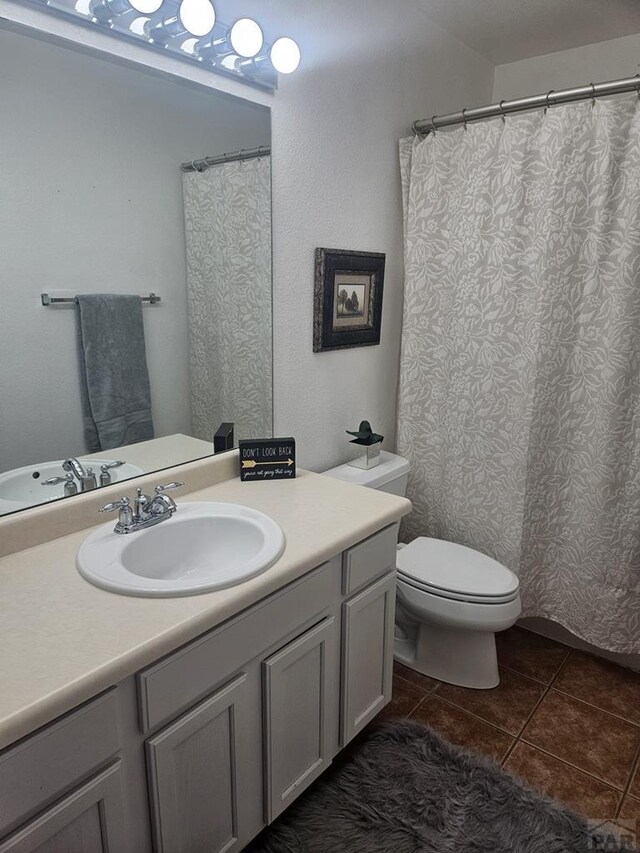 full bathroom featuring vanity, toilet, and tile patterned floors