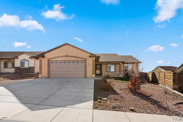 single story home featuring a garage, driveway, fence, a porch, and stucco siding