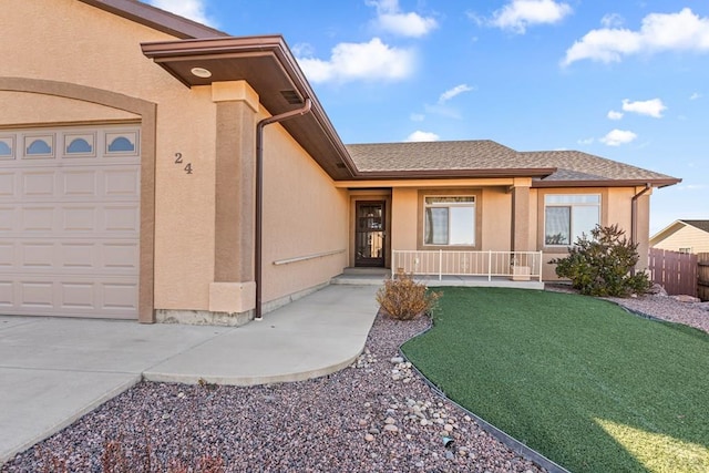 entrance to property featuring a porch, fence, an attached garage, and stucco siding