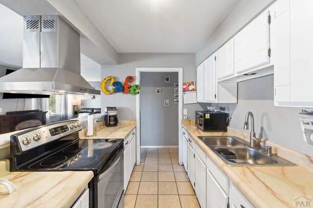 kitchen with island range hood, white cabinets, appliances with stainless steel finishes, light countertops, and a sink