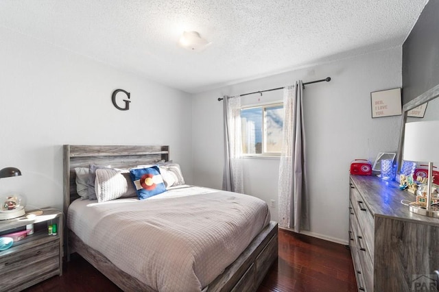 bedroom featuring a textured ceiling and dark wood-style flooring