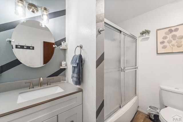 full bathroom featuring shower / bath combination with glass door, vanity, toilet, and wood finished floors