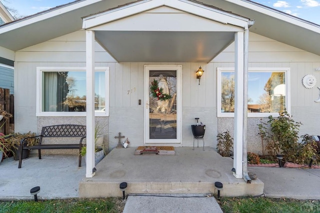 entrance to property featuring brick siding and a patio area