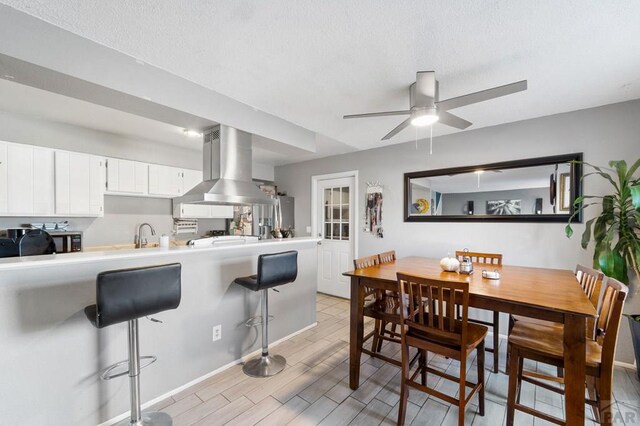 dining area with light wood finished floors and ceiling fan