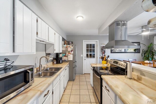 kitchen with appliances with stainless steel finishes, light countertops, island exhaust hood, and a sink