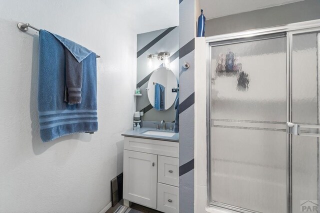 full bathroom featuring a stall shower and vanity