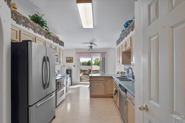 kitchen with light brown cabinets, a sink, light wood-style floors, light countertops, and appliances with stainless steel finishes