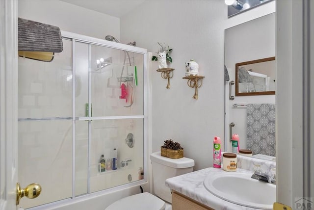 full bathroom featuring combined bath / shower with glass door, vanity, and toilet