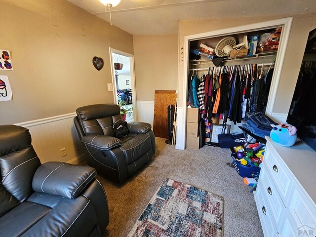 bedroom featuring carpet, a closet, and wainscoting