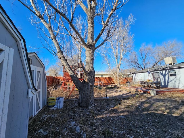 view of yard with a storage shed, a patio area, a fenced backyard, and an outdoor structure