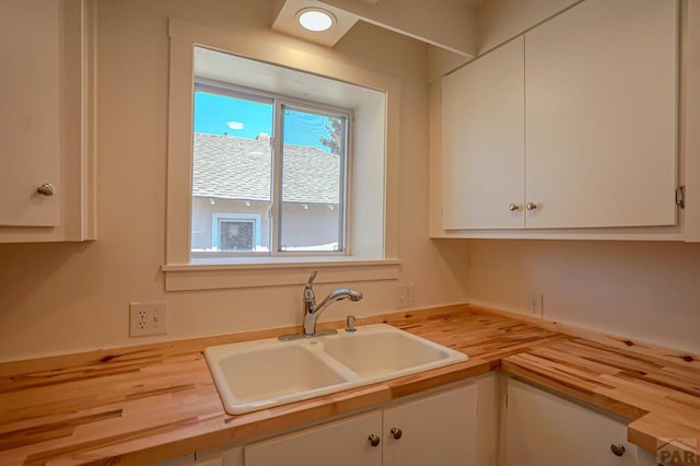 327/327.5 7th St, Walsenburg, CO 81089 - kitchen with wooden counters, a sink, and white cabinets