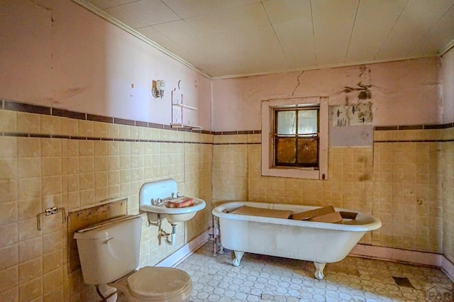 327/327.5 7th St, Walsenburg, CO 81089 - bathroom with tile walls, a freestanding bath, ornamental molding, toilet, and wainscoting