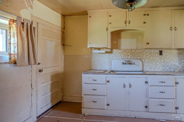 327/327.5 7th St, Walsenburg, CO 81089 - kitchen featuring light countertops, backsplash, and white cabinets