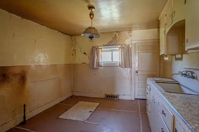 327/327.5 7th St, Walsenburg, CO 81089 - kitchen featuring a sink, light countertops, white cabinetry, and decorative light fixtures