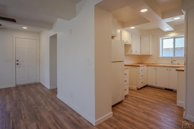 327/327.5 7th St, Walsenburg, CO 81089 - kitchen with freestanding refrigerator, a sink, dark wood finished floors, white cabinets, and recessed lighting