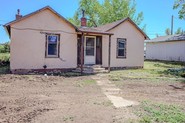 327/327.5 7th St, Walsenburg, CO 81089 - view of front facade with a chimney and stucco siding