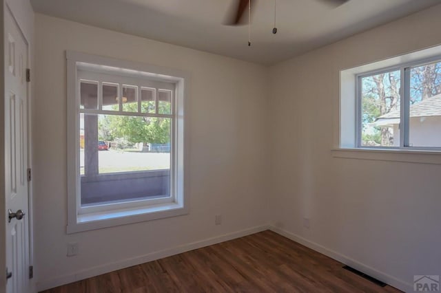 327/327.5 7th St, Walsenburg, CO 81089 - empty room featuring healthy amount of natural light, dark wood-style floors, baseboards, and ceiling fan