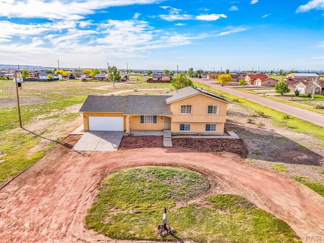 806 N Monarch Dr, Pueblo, CO 81007 - view of front facade featuring concrete driveway, stucco siding, a garage, and a residential view