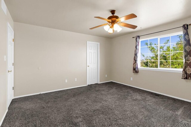 806 N Monarch Dr, Pueblo, CO 81007 - unfurnished room with dark colored carpet, a ceiling fan, and baseboards