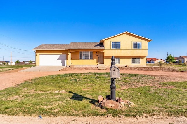 806 N Monarch Dr, Pueblo, CO 81007 - split level home with concrete driveway, an attached garage, stucco siding, and a front yard