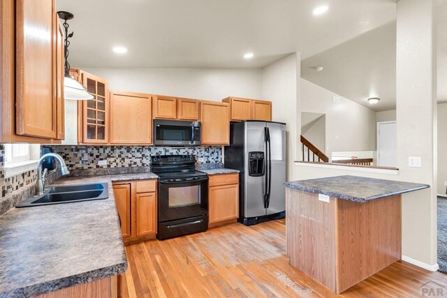 806 N Monarch Dr, Pueblo, CO 81007 - kitchen featuring stainless steel appliances, a sink, lofted ceiling, backsplash, and glass insert cabinets