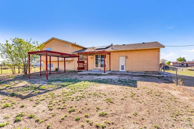 806 N Monarch Dr, Pueblo, CO 81007 - back of property with a patio, a fenced backyard, roof mounted solar panels, and stucco siding