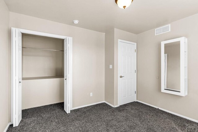 806 N Monarch Dr, Pueblo, CO 81007 - unfurnished bedroom featuring dark colored carpet, baseboards, and a closet