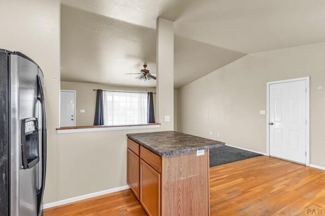 806 N Monarch Dr, Pueblo, CO 81007 - kitchen featuring stainless steel fridge with ice dispenser, a peninsula, light wood-style floors, a ceiling fan, and dark countertops