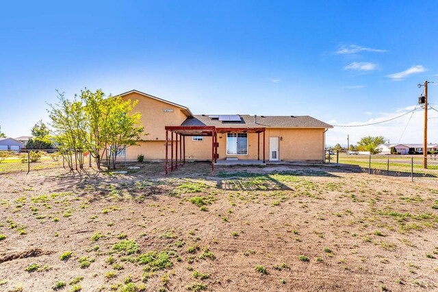806 N Monarch Dr, Pueblo, CO 81007 - back of property with roof mounted solar panels, a patio, a fenced backyard, and stucco siding