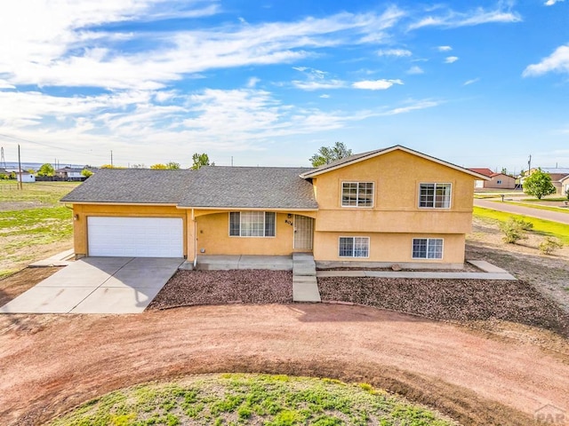 806 N Monarch Dr, Pueblo, CO 81007 - split level home featuring driveway, a garage, and stucco siding