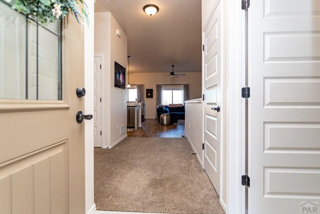 hallway with carpet floors and baseboards