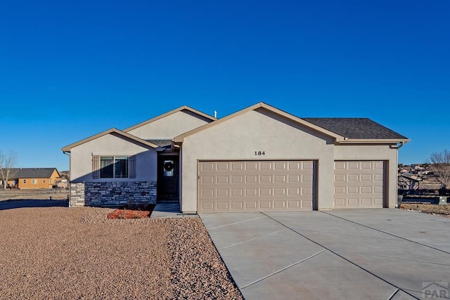 ranch-style home featuring a garage, concrete driveway, stone siding, and stucco siding