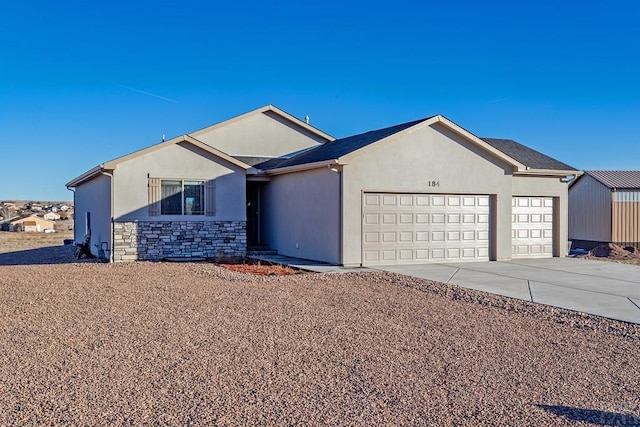 single story home with an attached garage, stone siding, driveway, and stucco siding