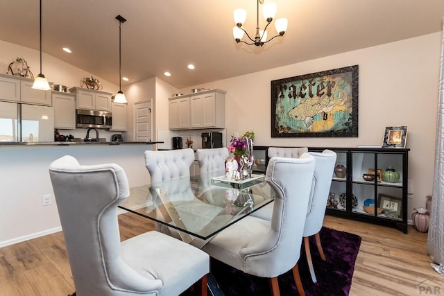 dining room with light wood finished floors, a chandelier, vaulted ceiling, and recessed lighting