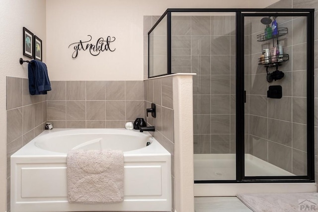 bathroom featuring a stall shower and a garden tub