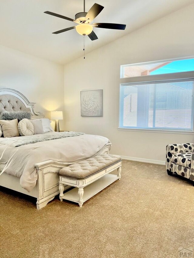 carpeted bedroom featuring a ceiling fan, lofted ceiling, and baseboards