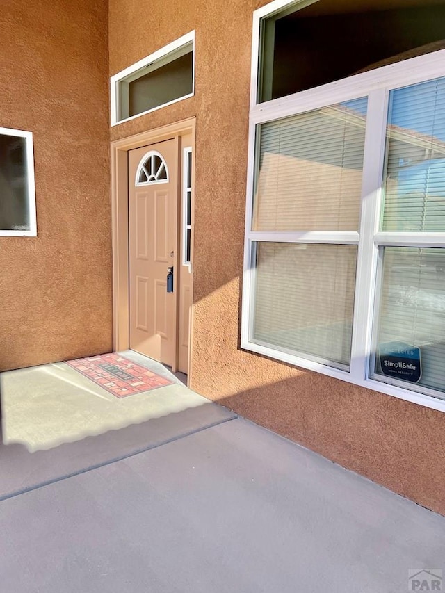 doorway to property featuring stucco siding