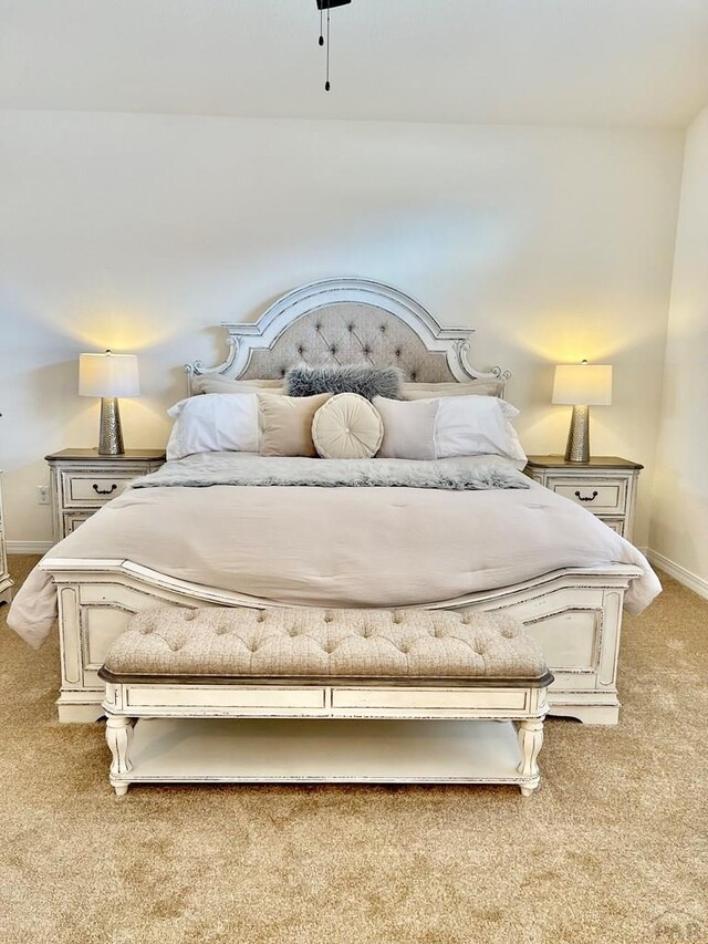 bedroom featuring light carpet and baseboards