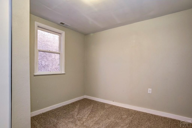 empty room with visible vents, baseboards, and carpet