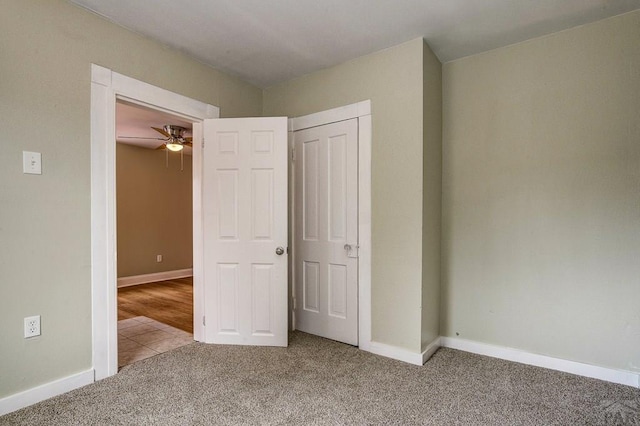 unfurnished bedroom featuring a closet, baseboards, and carpet floors