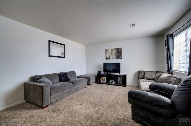 living room with baseboards, visible vents, and carpet flooring