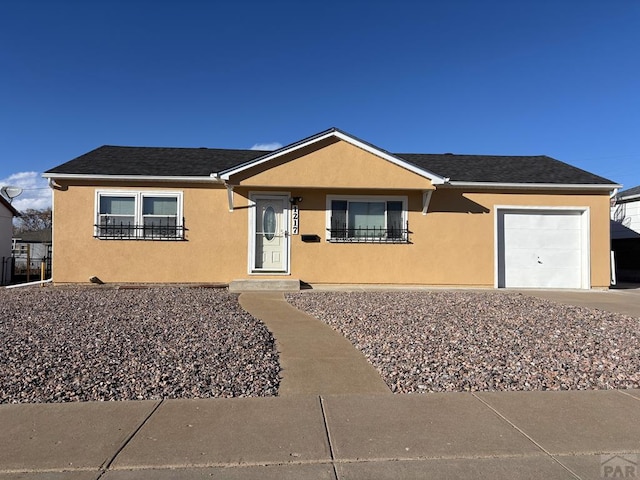 ranch-style home with a garage, roof with shingles, and stucco siding