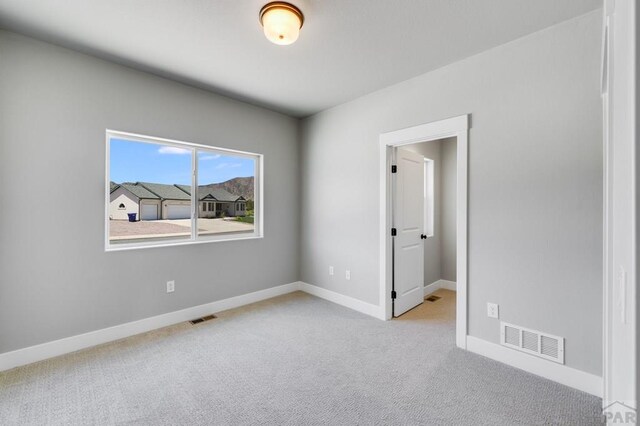 unfurnished bedroom with light carpet, baseboards, and visible vents