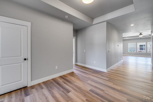 spare room with light wood-style flooring, baseboards, and ceiling fan