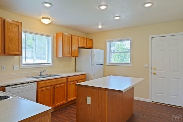 kitchen featuring a sink, light countertops, white appliances, and a kitchen island