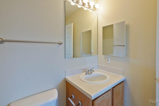 half bathroom with toilet and vanity