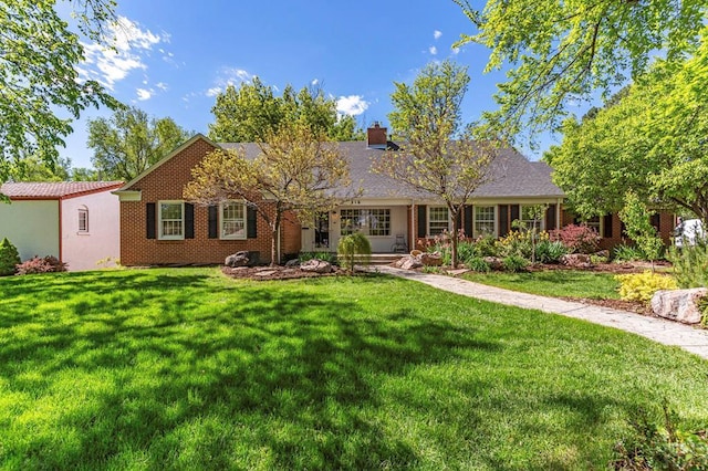 single story home with brick siding, a chimney, and a front lawn