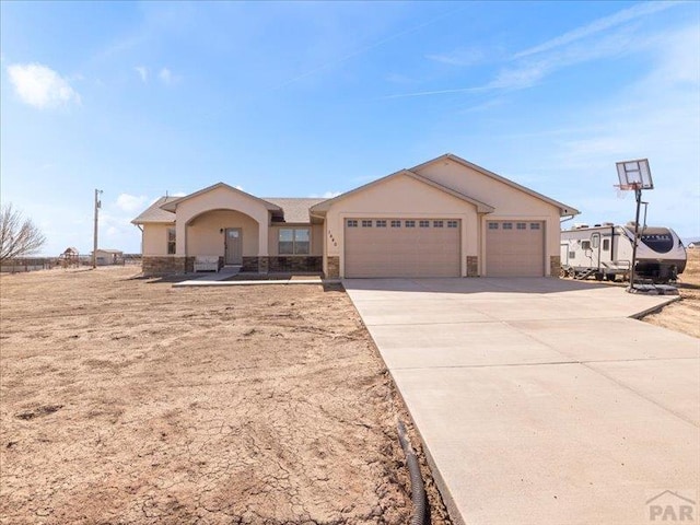 ranch-style home with a garage, concrete driveway, and stucco siding