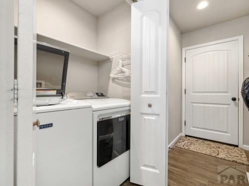 laundry room with laundry area, baseboards, wood finished floors, and independent washer and dryer